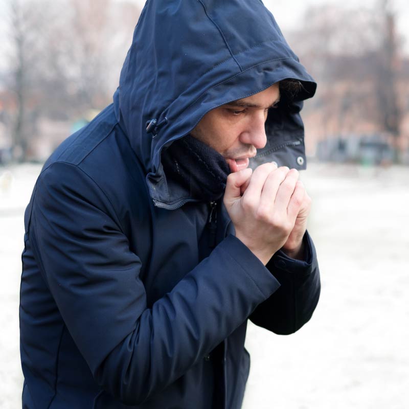 A man blows on his hands in the winter cold