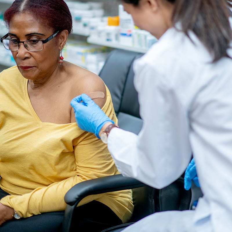 An older woman gets vaccinated at the pharmacy